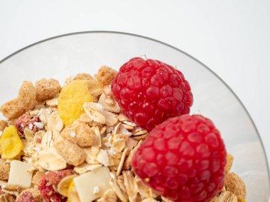 Muesli in a glass glass and berries on a white table. Muesli isolated on a white background.