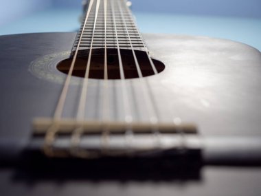 Black guitar on a blue background.