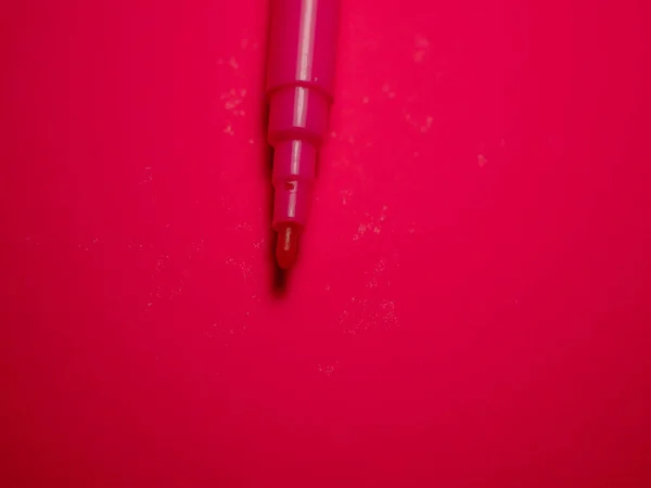 Red felt-tip pen on red background. Colored felt-tip pen.
