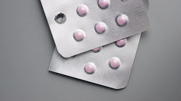 Pílulas cor de rosa em um fundo cinza. — Vídeo de Stock