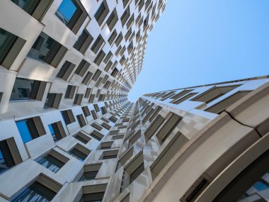 Mavi gökyüzüne karşı yüksek binalar.