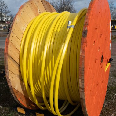 İnşaat alanında veri kabloları yerleştirmek için sarı fiber optik kablolu ahşap silindir..