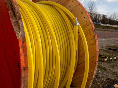 İnşaat alanında veri kabloları yerleştirmek için sarı fiber optik kablolu ahşap silindir..