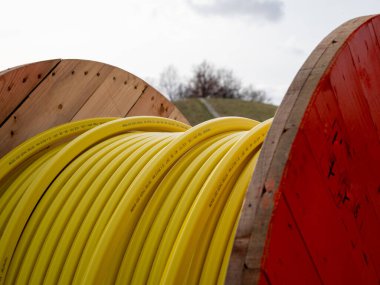 İnşaat alanında veri kabloları yerleştirmek için sarı fiber optik kablolu ahşap silindir..