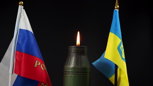 乌克兰和俄罗斯国旗在一个燃烧的弹壳的背景下. — 图库视频影像