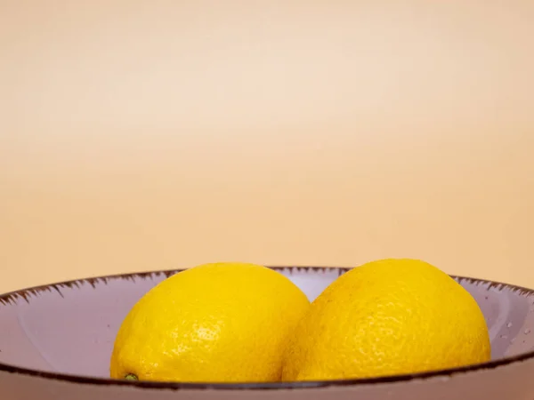 Πιάτο Φρέσκα Λεμόνια Στο Τραπέζι Πορτοκαλί Φόντο — Φωτογραφία Αρχείου