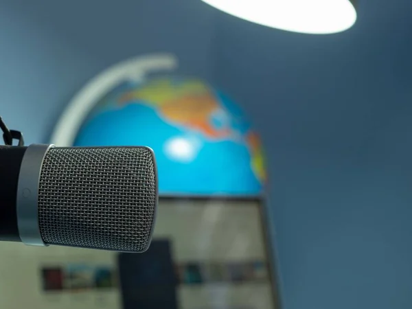 Ev stüdyosu podcast iç mekan. Mikrofon, dizüstü bilgisayar ve küre masanın üstünde, yakın plan..