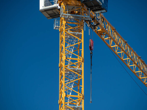 Tower crane against the blue sky. Close-up.