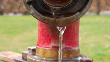 Çimlerin arasından akan açık bir su vanasının ayrıntıları.