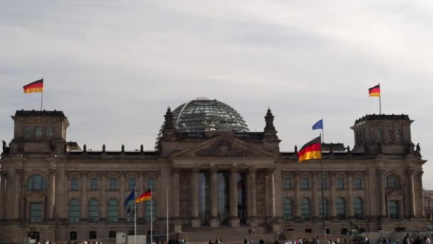 Német zászlók lobognak a szélben a Reichstag épületnél Berlinben, Németországban. — Stock videók