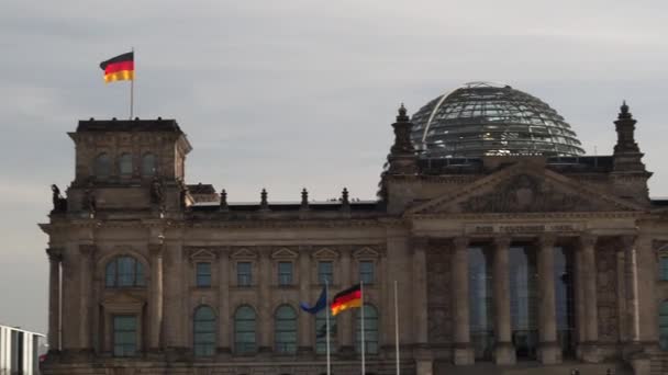 Német zászlók lobognak a szélben a Reichstag épületnél Berlinben, Németországban. — Stock videók