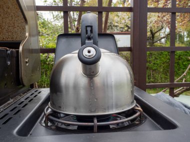 Tencere dibin kara seninki benden kara. Gaz ocağında çaydanlık.