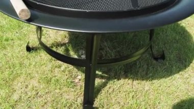 Yeşil otların arka planında ateş için metal kase. Kapaklı metal ateş kasesi..