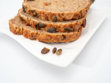 Beyaz arka planda kabak tohumlu ekmek. Balkabağı ekmeği.