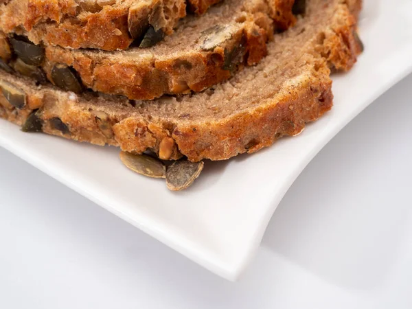 Beyaz arka planda kabak tohumlu ekmek. Balkabağı ekmeği.