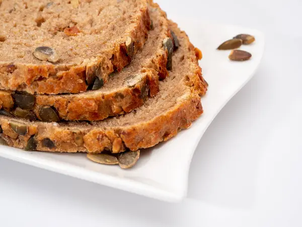 Beyaz arka planda kabak tohumlu ekmek. Balkabağı ekmeği.