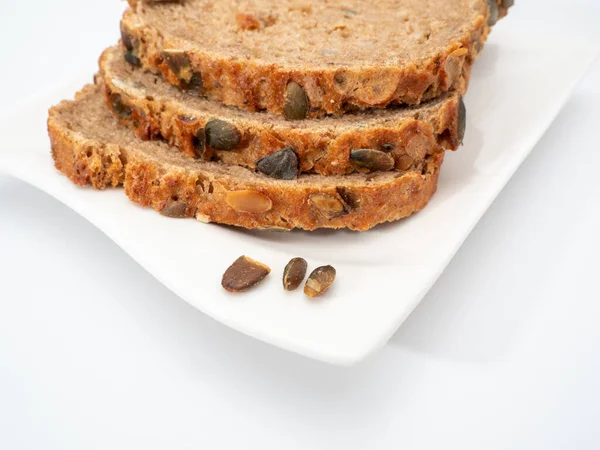 Beyaz arka planda kabak tohumlu ekmek. Balkabağı ekmeği.