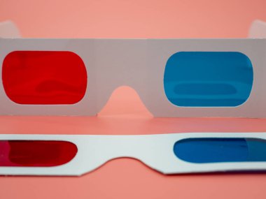 3D film ve görüntüleri izlemek için kırmızı ve mavi kağıt gözlük. Pembe arka planda izole edilmiş..