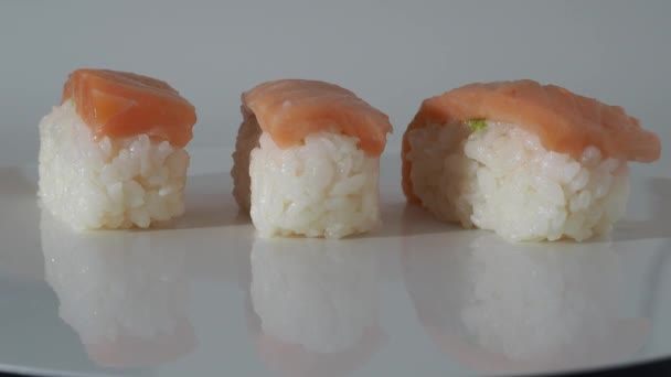 Sushi tourner sur un fond blanc. sushi gros plan. — Video