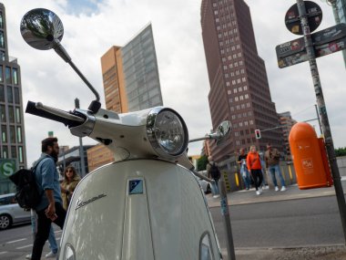 BERLİN, Almanya - 21 Mayıs 2022; Scooter gökdelenlerin arka planında. Retro moped. Podzdamer platz. 21 Mayıs 2022 Berlin Almanya