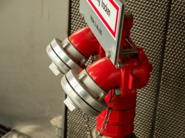 Binada yangın musluğu var. Kırmızı yangın musluğu.