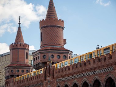 Berlin 'de sarı tren. Tren istasyonda. Berlin, Almanya 'daki Oberbaum köprüsünde sarı tren