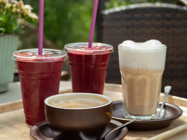 Coffee, cappuccino and smoothies on a table in a cafe. Fruit smoothies and coffee drink.