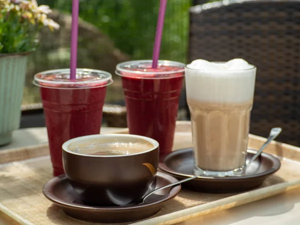 Coffee, cappuccino and smoothies on a table in a cafe. Fruit smoothies and coffee drink.