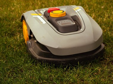 Robot çim biçme makinesi. Elektronik çim biçme makinesi çimleri biçiyor..