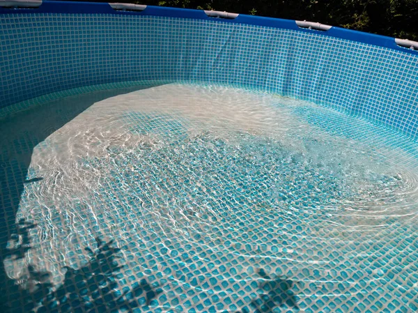 The pool is filled with water. Water runs into the pool.