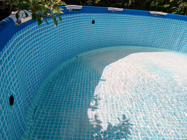 The pool is filled with water. Water runs into the pool.