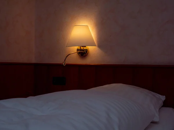 ホテルのベッドの脇のランプ — ストック写真