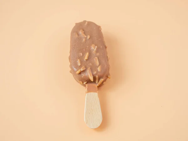 スティックにアーモンドとチョコレートアイスクリーム オレンジの背景にアイスクリーム — ストック写真