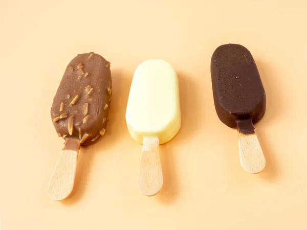棒の上に3種類のアイスクリーム オレンジの背景にアイスクリーム — ストック写真