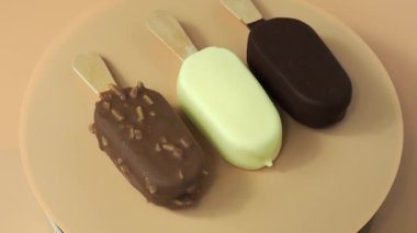 Different varieties on a stick. Ice cream on an orange background. High quality 4k footage