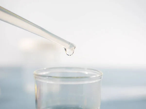 Analytical chemistry - sample being pipetted into test tube for analysis in laboratory.