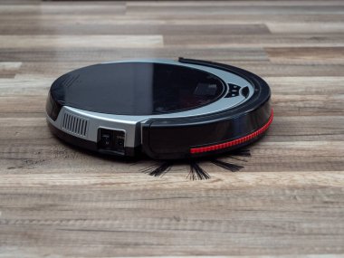 Kaplamalı ahşap zeminde robot elektrikli süpürge. Robot elektrikli süpürge..