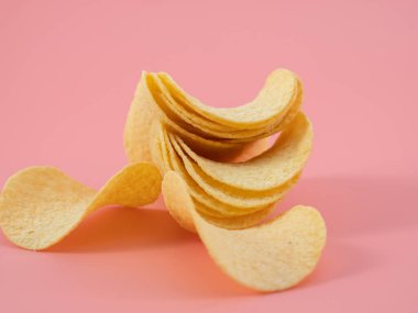 Cipsler. Çıtır patates. Pembe arka planda patates cipsi. Yakın plan..
