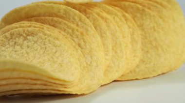 Fried potato chips rotating on a white background. Crispy chips. High quality 4k footage