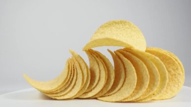 Fried potato chips rotating on a white background. Crispy chips. High quality 4k footage