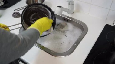 Evde, mutfakta bulaşık yıkayan bir adamın görüntüsü. Yüksek kalite 4k görüntü