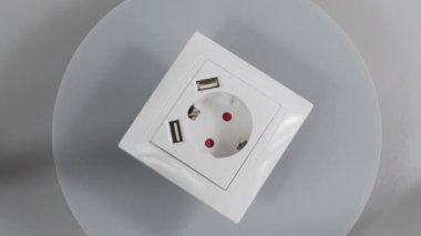 İki USB prizi ve iki USB bağlantısı olan bir soket. 220 volt Avrupa standart soketi ve iki usb bağlantı aygıtı şarj etmek için. Beyaz arka planda beyaz plastik soket
