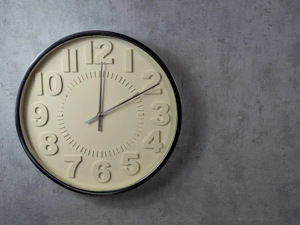 Wall clock on a gray background. Clock close-up. Watch face with large numbers.