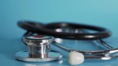 Medical stethoscope rotates on a blue background.