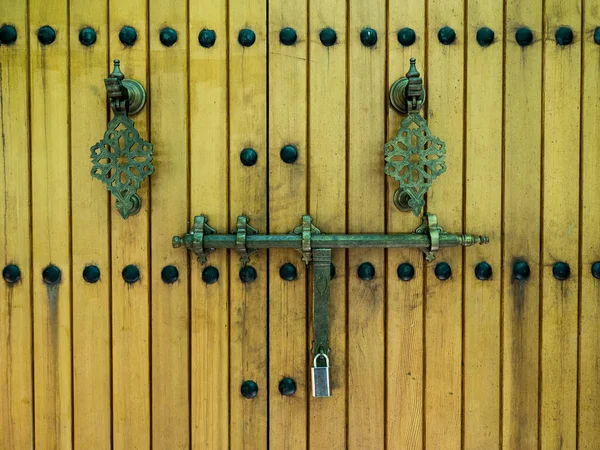 Ancient wooden gate. Gate with old metal handles. Close up.