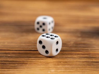 Dice on a dark wooden background. Playing dice on a wooden table. Close up.