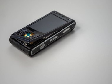 Old push button mobile phone. Broken phone. Phone on a gray background.