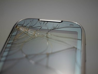 Old smartphone. Broken phone. Phone on a gray background. Broken smartphone.