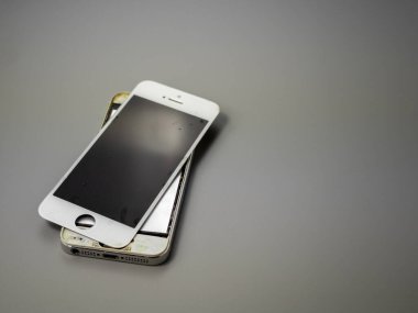 Old smartphone. Broken phone. Phone on a gray background. Broken smartphone.