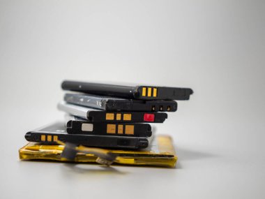 Old phone batteries. Replaceable batteries. Phone batteries. Batteries on a gray background. .